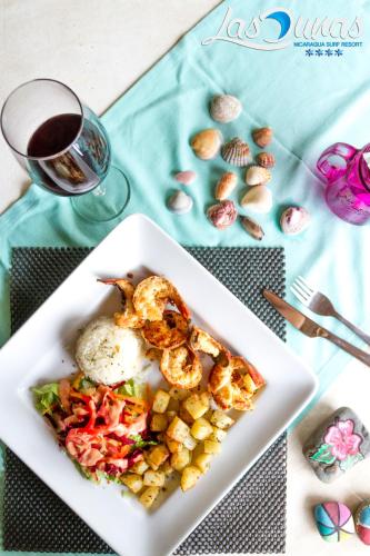 a plate of food with eggs and vegetables on a table at Las Dunas Surf Resort in Aposentillo