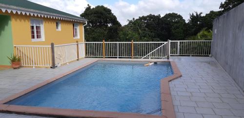 a small swimming pool in a backyard with a fence at La créola BAYALOCATION in Rivière-Pilote