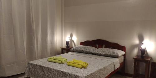 a bedroom with a bed with yellow towels on it at Villa Skanderbeg Guest House in Puerto Princesa City
