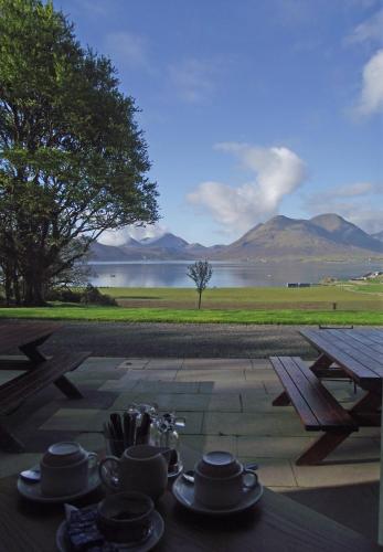 a picnic table with a view of a lake and mountains at Raasay House Hotel in Raasay