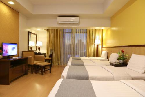 Ліжко або ліжка в номері The Malayan Plaza Hotel