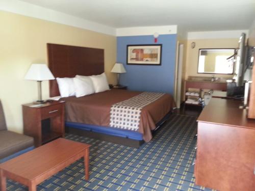 a hotel room with a bed and a chair at Days Inn by Wyndham Fultondale in Fultondale
