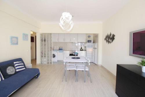 a living room with a table and chairs and a kitchen at Solmonte White and Blue in Portimão