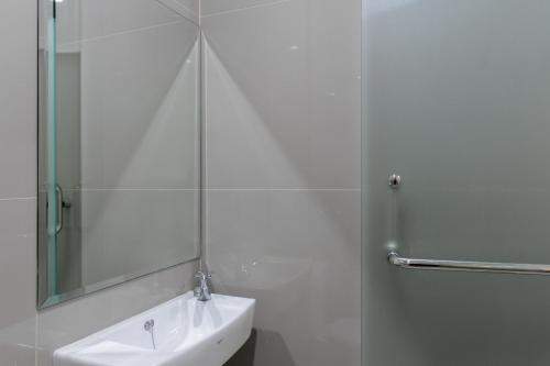 a bathroom with a sink and a shower with a mirror at RedDoorz near Mall SKA Pekanbaru in Pekanbaru