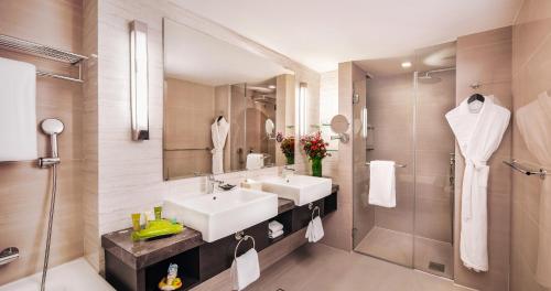a bathroom with a sink and a shower and a mirror at Royal Plaza on Scotts in Singapore