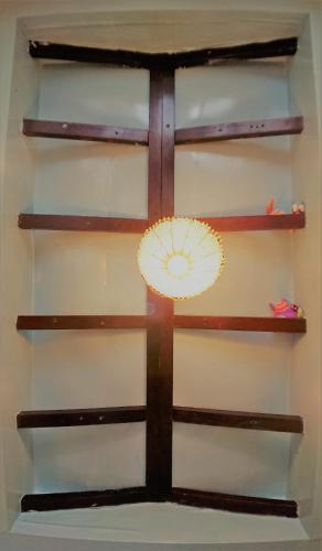 a wall with wooden shelves and a fan on it at DOWN HWA NO.8 in Pinghe