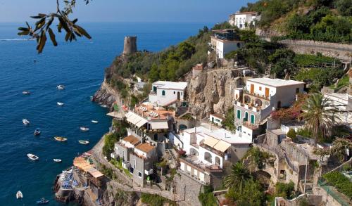 a group of houses on a cliff next to the water at Hotel Onda Verde in Praiano