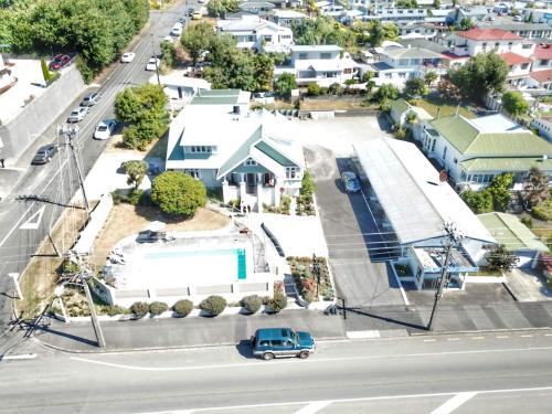 a blue car driving down a city street with houses at Picton House B&B and Motel in Picton