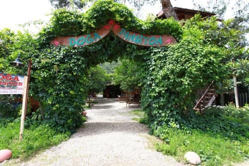 an entrance to a garden with an arch covered in ivy at Olympos Doga Pansiyon in Olympos