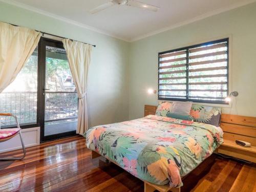 a bedroom with a bed and two windows at Billa Blue in Point Lookout