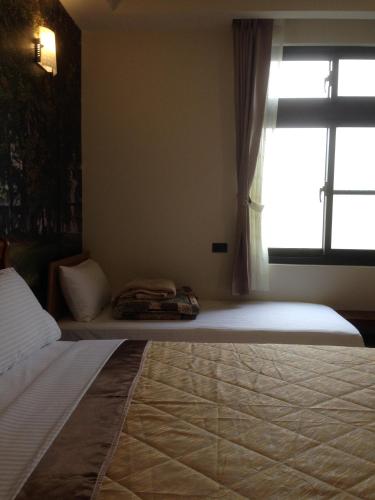 a bedroom with a large bed with a window at Hongfu Elegant Business Hotel in Zhongli