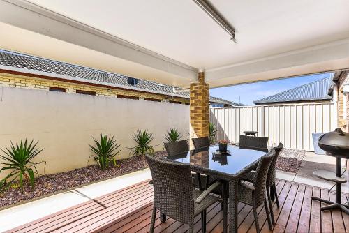 un patio con tavolo e sedie su un ponte di City Fringe Apartment a Mount Gambier