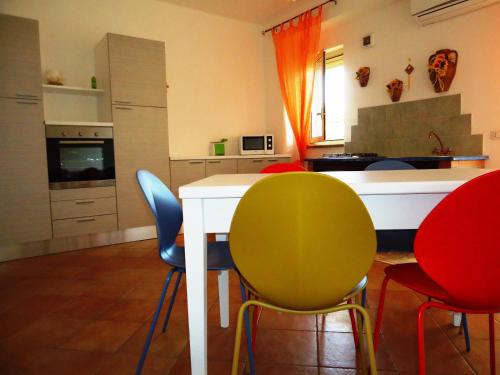 a kitchen with red and green chairs and a table at Ciuscia in Calatabiano