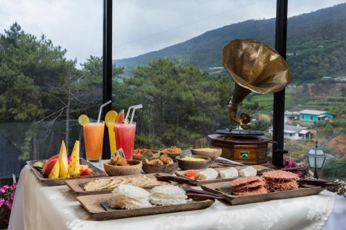 a buffet of food on a table with a view at CheRiz Boutique Villa Hotel in Nuwara Eliya
