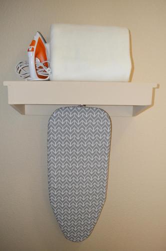 a white shelf with a tie and a roll of paper at Sea Breeze Inn - San Simeon in San Simeon