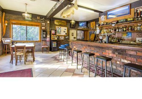 um restaurante com um bar com mesas e cadeiras em Lake Leake Inn em Lake Leake