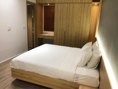 a bedroom with a bed with white sheets and a window at Khe Suites Le Lai Apartment - Self Check-in with Lockbox in Da Nang