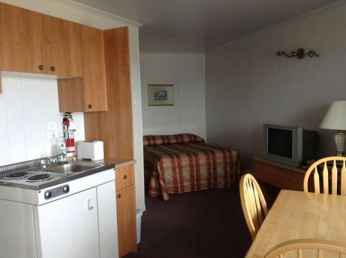 Habitación de hotel con cocina y cama en Motel Nouvel Horizon en Perce