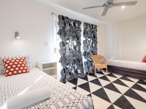 um quarto com uma cama e um piso em xadrez preto e branco em Stradbroke Sunset em Point Lookout