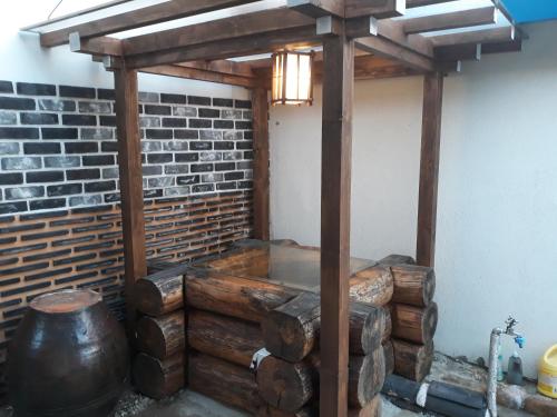 uma banheira de hidromassagem num quarto com uma parede de tijolos em Namuae em Gyeongju