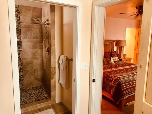 Un baño con ducha y una cama. en Oleander Place, en Moab