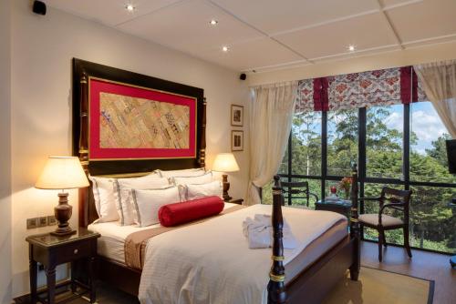 
a bedroom with a large bed and a large window at CheRiz Boutique Villa Hotel in Nuwara Eliya

