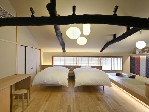 two beds in a large room with two beds sidx sidx sidx at Kyo no Ondokoro FUYACHO-NIJO #4 in Kyoto