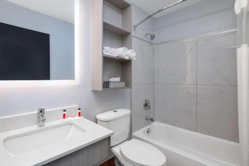 een badkamer met een toilet, een wastafel en een douche bij Microtel Inn by Wyndham Lake Norman in Cornelius