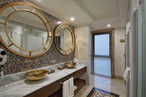 a bathroom with two sinks and a large mirror at Nirvana Mediterranean Excellence - Ultra All Inclusive in Beldibi