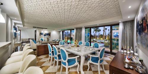 a dining room with a table and blue chairs at Nirvana Mediterranean Excellence - Ultra All Inclusive in Beldibi