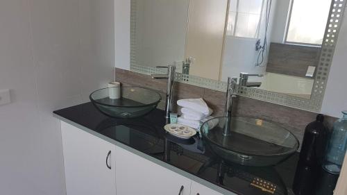a bathroom with two glass sinks on a counter at Santalina On Hervey Bay in Hervey Bay