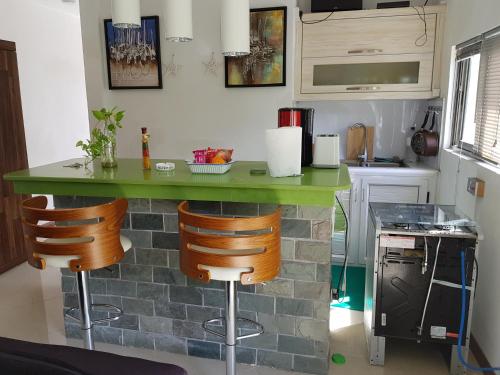 a kitchen with a green counter and stools at MountView studio in city in Port Louis