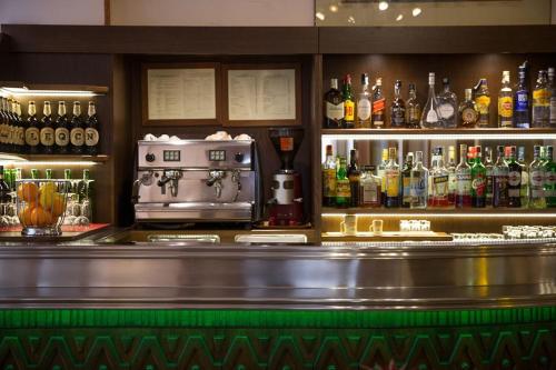 ピサにあるホテル テルミヌス ＆ プラザのアルコールのボトルを多数取り揃えたバー