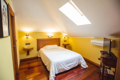 a bedroom with a white bed and yellow walls at Hotel El Sella in Cangas de Onís
