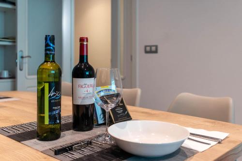 two bottles of wine and a bowl on a table at BIG LUX BEACHCITY Ap 01 in Bilbao
