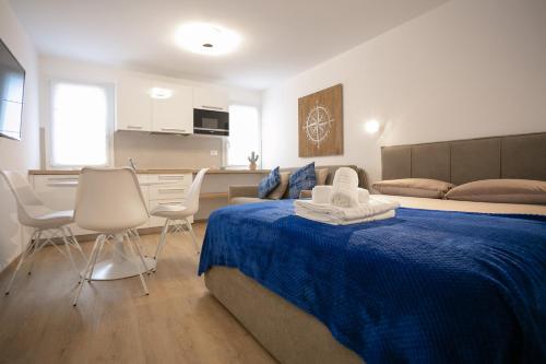 a bedroom with a bed with a blue blanket and chairs at Casa Azzurra in Chioggia