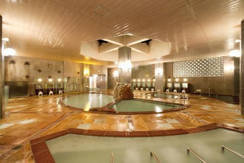 a large room with a hot tub in the middle at Yumoto Noboribetsu in Noboribetsu