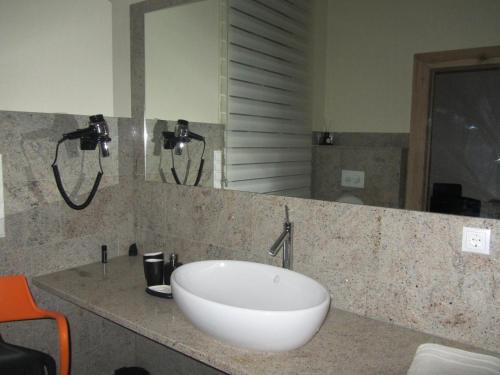 a bathroom with a white sink and a mirror at Exklusive Gästezimmer Landau in Landau in der Pfalz