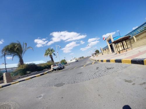 a car driving down a road next to a building at Cozy Apartment Freedom in Hurghada