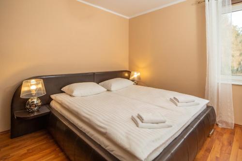 een slaapkamer met een groot bed met 2 witte kussens bij Morskie Oko II by Renters in Międzyzdroje