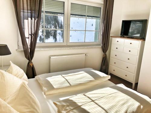 1 dormitorio con cama blanca y ventana en Hubertus Dependance en Obertauern