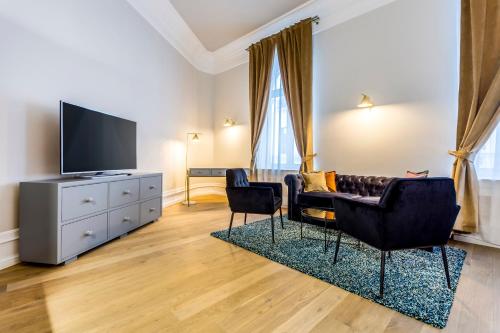 a living room with two chairs and a television at Matisse Bucharest Old Town in Bucharest