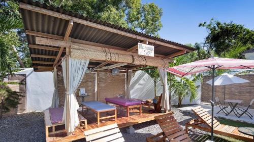 a patio with a table and chairs and an umbrella at Island World Panglao in Panglao