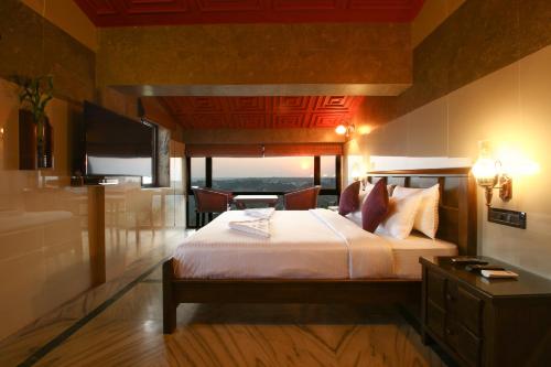 a bedroom with a large bed and a television at Hill Top Luxury Villa - 3 BHK || Infinity Pool in Mapusa