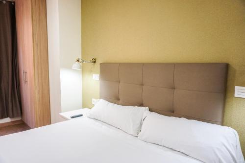 a bedroom with a large bed with white sheets and pillows at Hotel Lidar in Bilbao