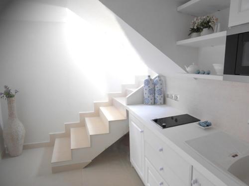 a white room with a staircase and a sink at HydraVista (Coral) in Hydra