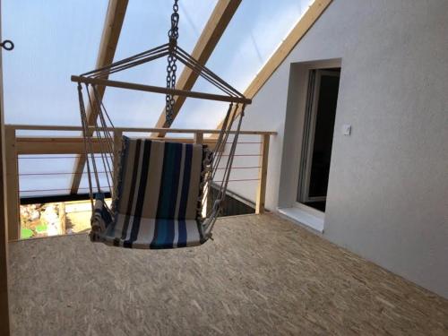 a swinging chair in a room with a balcony at Chalupa U dedka in Legnava