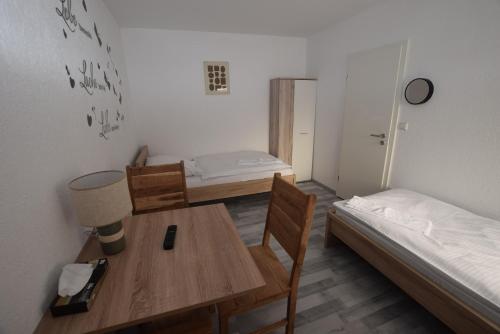 um quarto com uma secretária, uma cama, uma mesa e cadeiras em Wohnung Bad Cannstadt em Stuttgart