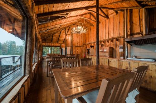 a dining room with a wooden table and chairs at Huilo Huilo Canopy Village in Huilo Huilo