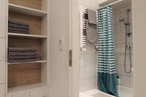 La salle de bains est pourvue d'une douche et d'un rideau de douche. dans l'établissement 2-room apartment, à Hanovre
